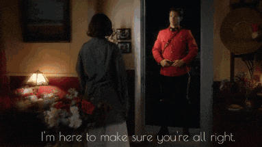 a man in a red uniform is standing next to a woman who says i 'm here