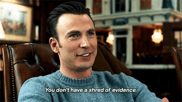 a man in a blue sweater is sitting in a chair with the words `` you don 't have a shred of evidence ''
