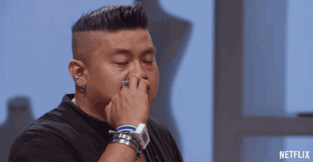 a man covering his nose with his hand with a netflix logo in the corner