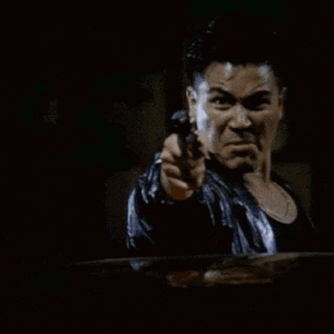 a man in a leather jacket is holding a gun in his right hand