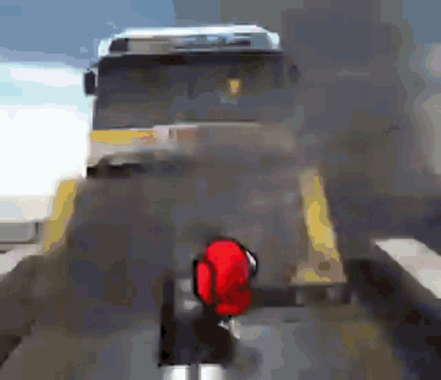 a bus is driving down a road with smoke coming out of the back
