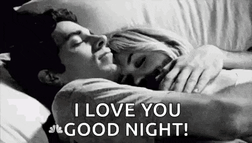 a man and a woman are sleeping in a bed and the man is hugging the woman .