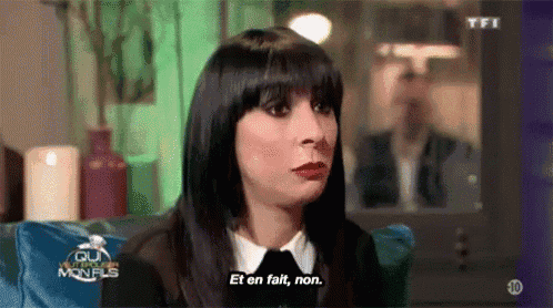 a woman is sitting on a couch and says et en fait , non .