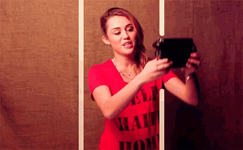 a woman wearing a red shirt that says " i love you " is taking a selfie