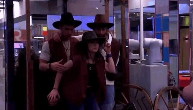 a group of people wearing cowboy hats and vests are standing next to each other .