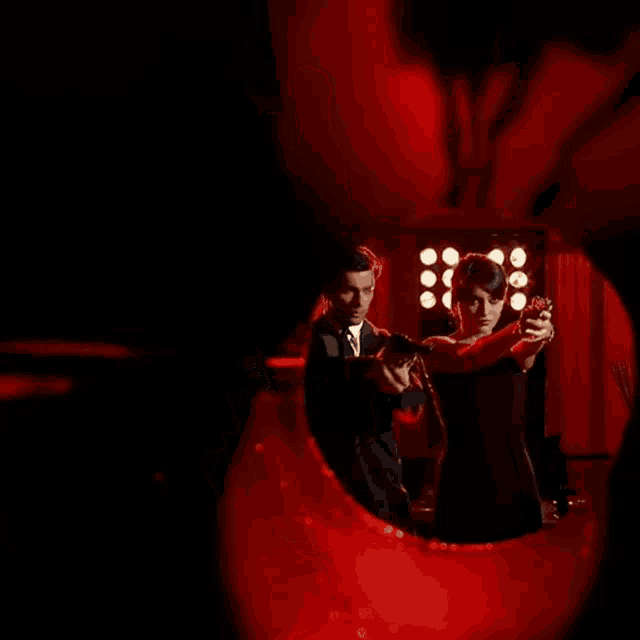 a man is pointing a gun at a woman 's face