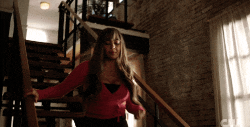 a woman in a red top is walking up a set of stairs