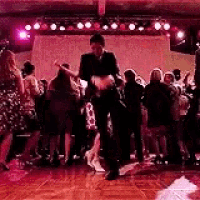 a man and a woman are dancing on a dance floor in front of a crowd .