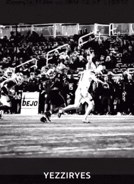 a black and white photo of a football player running on a field