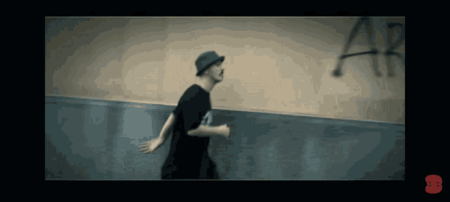 a man wearing a hat is running in front of a wall that has the word ar written on it