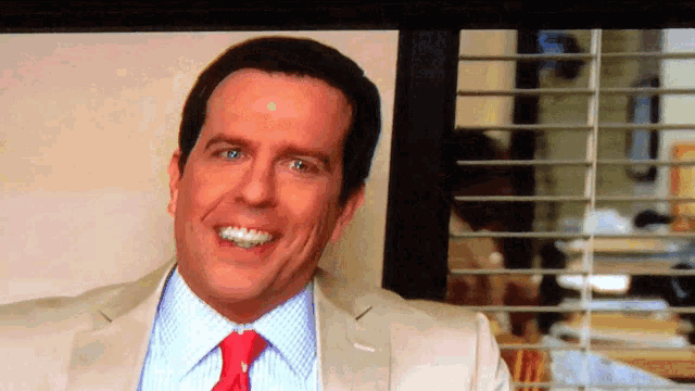 a man in a suit and tie is smiling