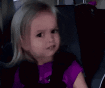 a close up of a little girl 's face in a purple shirt .