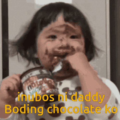 a little girl with chocolate on her face is eating a chocolate can