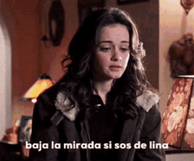 a woman says baja la mirada si sos de lina in front of a lamp