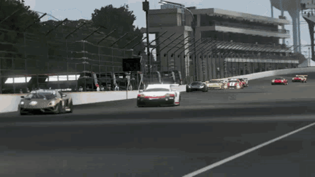 a group of cars are racing on a race track with a building in the background