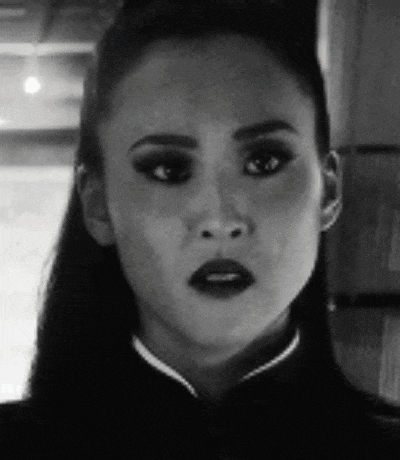 a close up of a woman 's face in a black and white photo with a serious look on her face .
