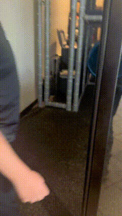 a person is standing in front of a door that has a grid pattern on it