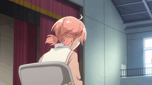 a girl with pink hair sits in a chair in front of a curtain