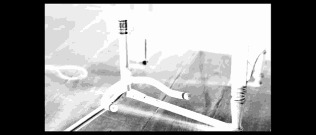 a black and white photo of a bicycle frame on a wooden table