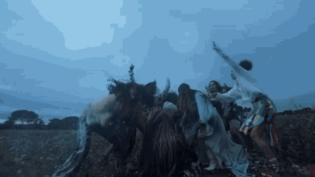 a group of people are standing in a field with their arms outstretched