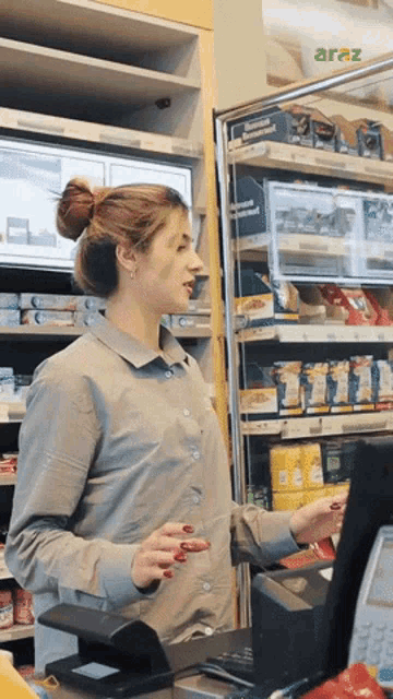 a woman standing in front of a refrigerator that says araz