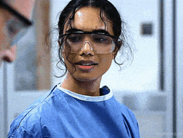 a close up of a woman wearing goggles and a scrub top