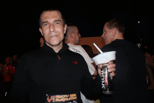 a man holding a cup and a can of special