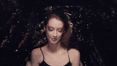 a woman blowing a kiss with a black background