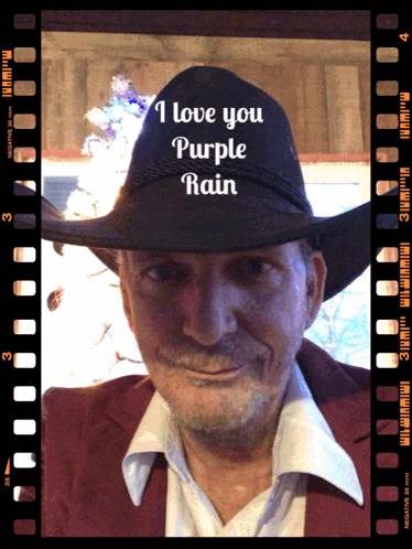 a man wearing a cowboy hat with the words i love you purple rain on it