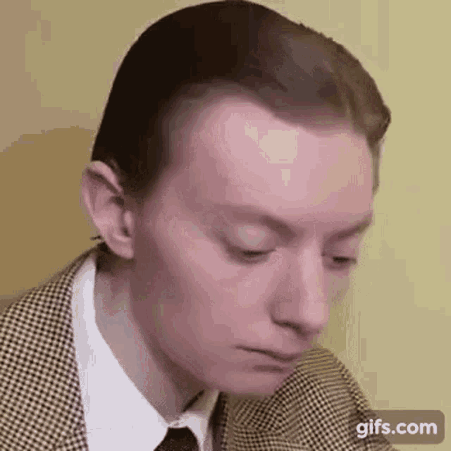 a close up of a man in a suit and tie making a funny face .