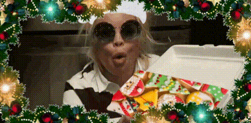 a woman wearing sunglasses and a chef 's hat is holding a box of cookies