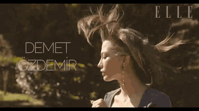 a woman 's hair is blowing in the wind and the name demet ozdemir is visible