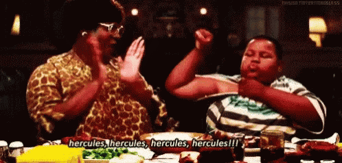 a man and a woman are sitting at a table with a sign that says hercules hercules hercules hercules !!!