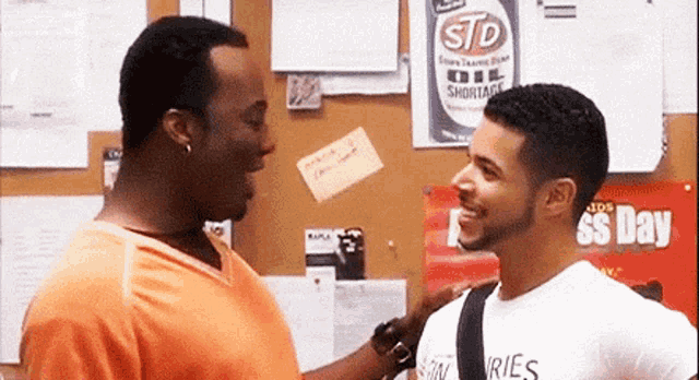two men are standing next to each other in front of a bulletin board with a std oil shortage sign on it