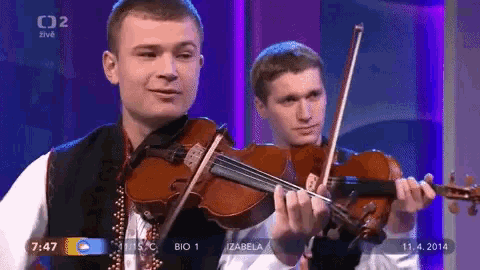 two men are playing violins in front of a purple background and the date is 11.4.2014