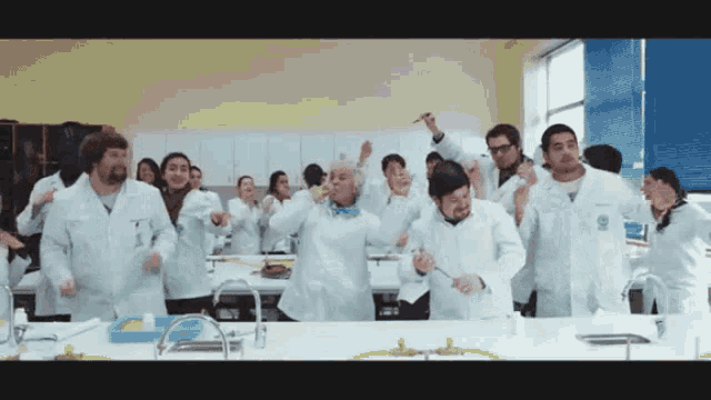 a group of people in lab coats are dancing together