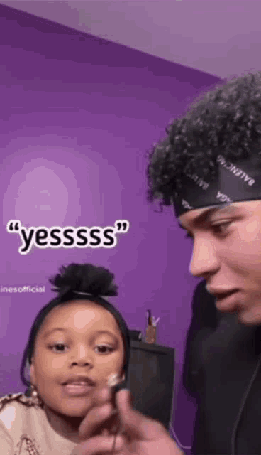 a man wearing a headband that says balenciaga on it talks to a little girl