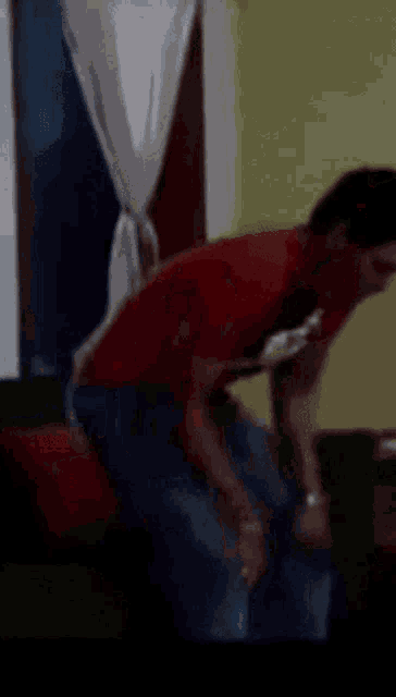 a blurry picture of a man in a red shirt looking down