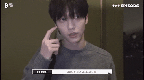 a young man wearing a grey sweater is talking on a cell phone with the name soobin on the bottom of the screen