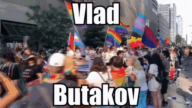 a crowd of people holding rainbow flags and a sign that says vlad butakov on it