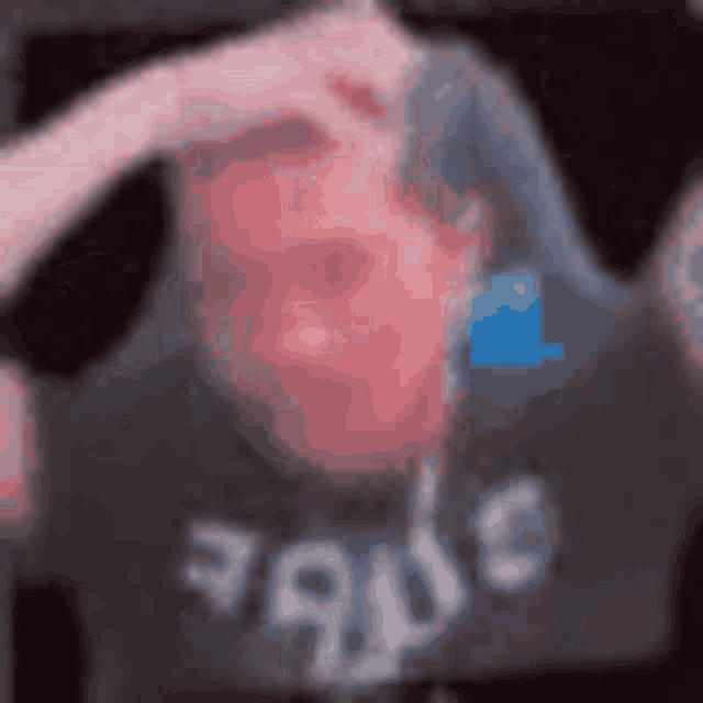 a blurry picture of a person wearing a black shirt with the word rage written on it .