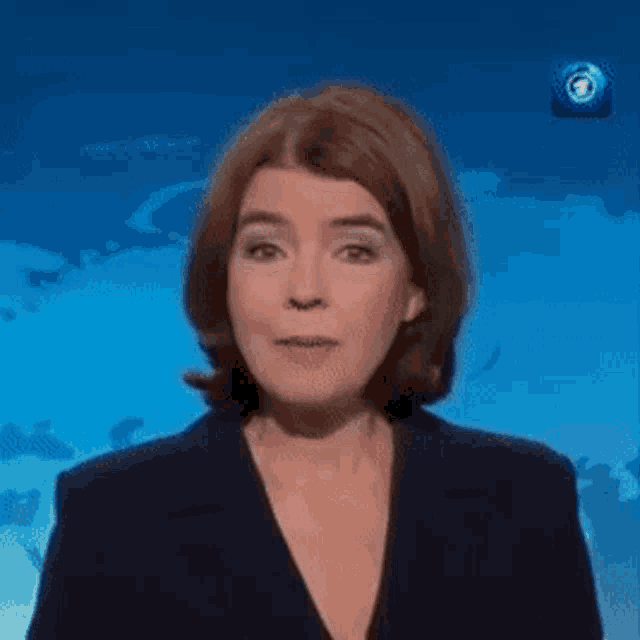 a woman in a suit says mittwoch in front of a blue background .