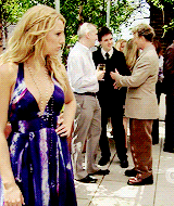 a woman in a blue dress stands in front of a group of men