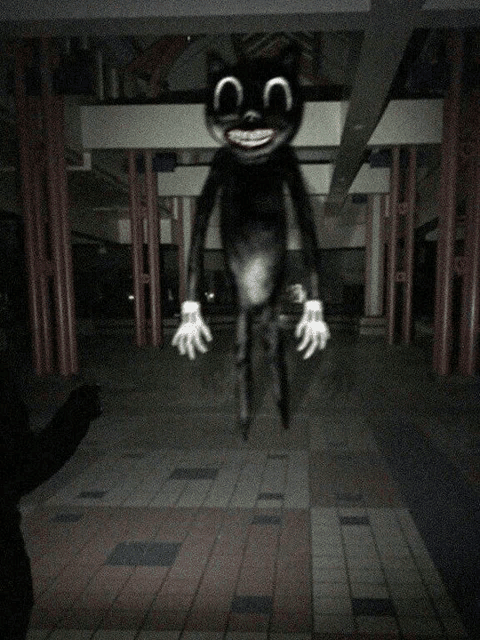 a cartoon cat with a big smile on its face is standing in the dark