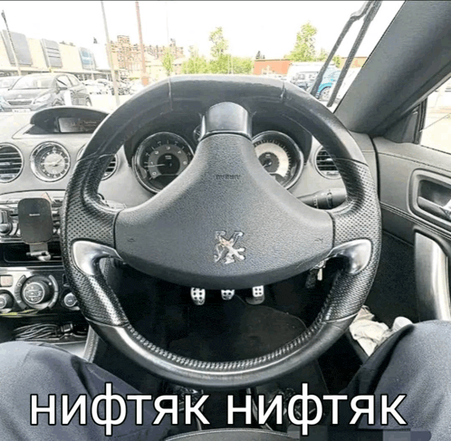 a steering wheel in a car with a peugeot logo