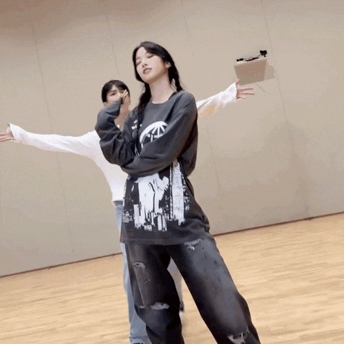 a girl wearing a shirt that says ' the punisher ' is dancing with another girl