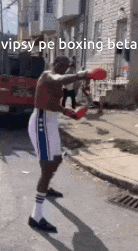 a man wearing boxing gloves is standing on a street with the words vipsy pe boxing beta written on the bottom