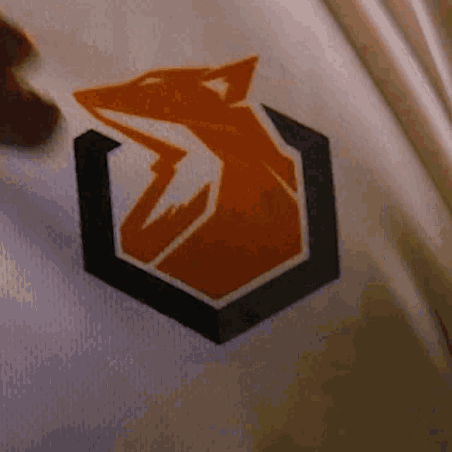 a close up of a white shirt with an orange fox on it