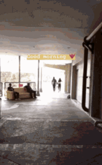 a couple walking down a hallway with a good morning sign above them