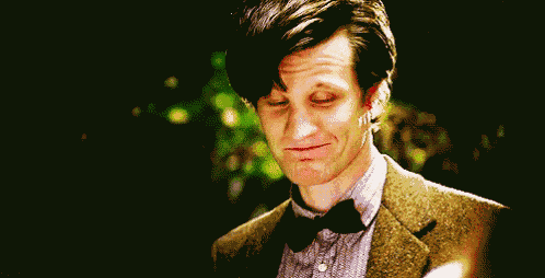 a close up of a man wearing a suit and bow tie making a funny face .